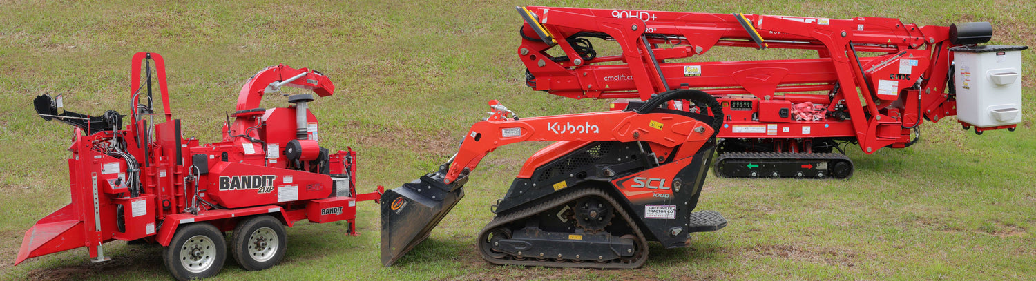 Three construction vehicles on a grassy field
